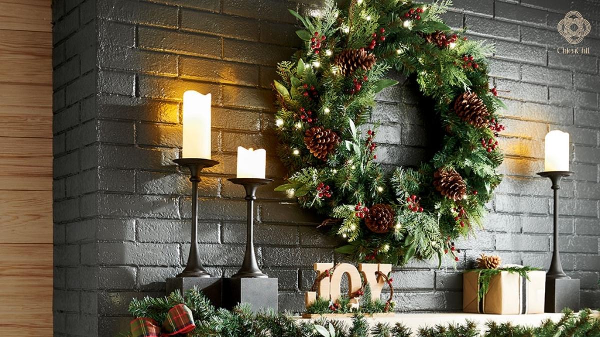 Festive greenery and soft candlelight transform the brick wall into a warm seasonal focal point.