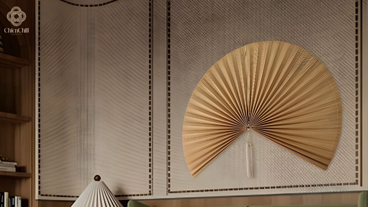 Two different-sized natural bamboo folding fans mounted on a textured wall.