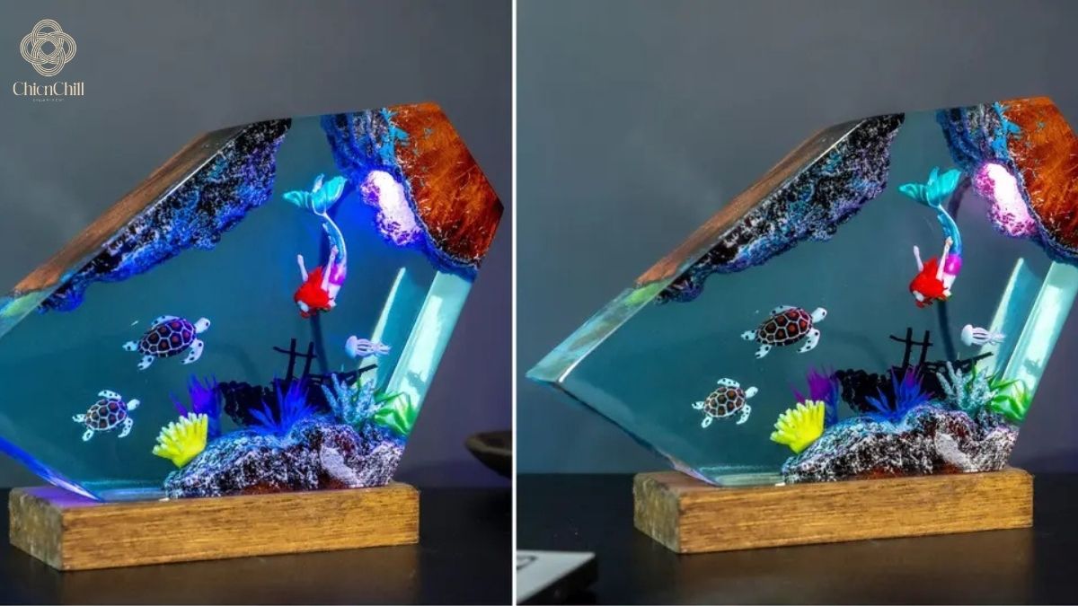 A handmade ocean-themed resin lamp on a wooden base featuring a sea turtle, coral reef, and a goldfish suspended in clear blue epoxy.